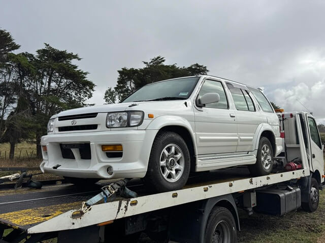 White SUV loaded on a flatbed tow truck for car removal in Auckland